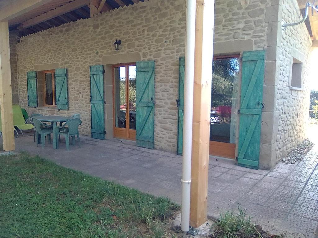 Casa con patio con mesa y sillas en Domaine des cigales, gîte Les cèdres, en Saint-Martin-dʼAoût