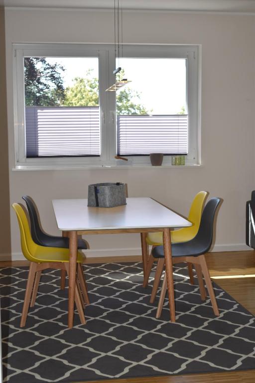 uma mesa e cadeiras num quarto com duas janelas em TOP Ferien Apartment Bohmte em Bohmte