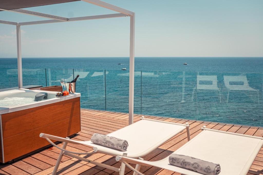 two chairs and a sink on a deck with the ocean at Nautilus Hotel in Giardini Naxos