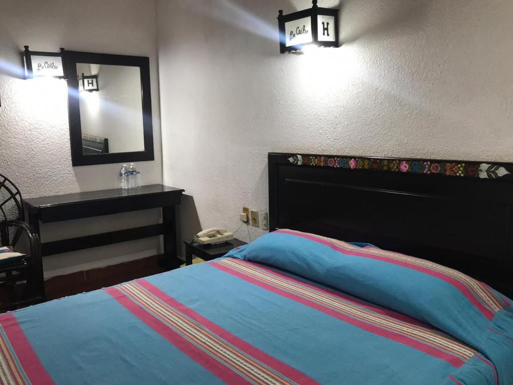 um quarto com uma cama, um toucador e um espelho. em Yaxché em Chiapa de Corzo