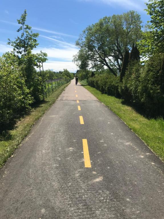 an empty road with a person walking down it at Auberge Lac St-Jean Phase 2 in Roberval