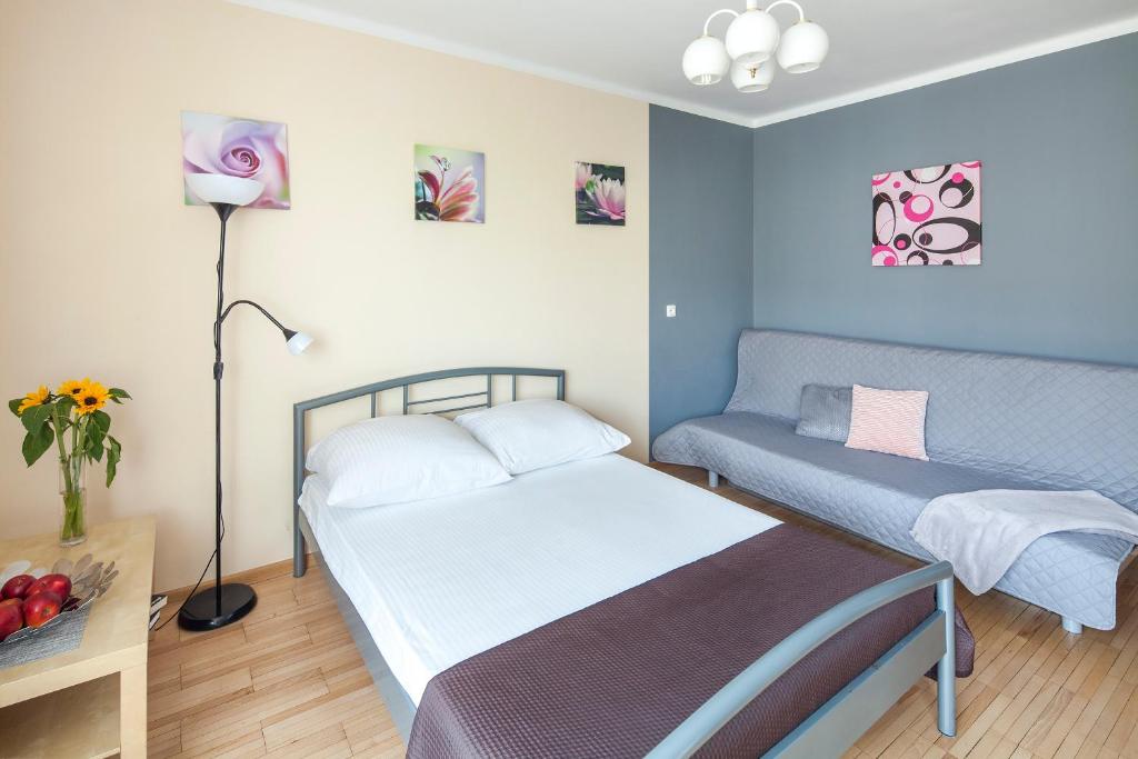 Habitación pequeña con cama y sofá en Sleepy3city Slaska 31 en Gdynia