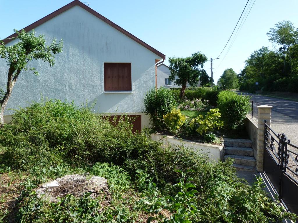 una casa con un patio con arbustos y árboles en Chez Jeannette, en Lacanche