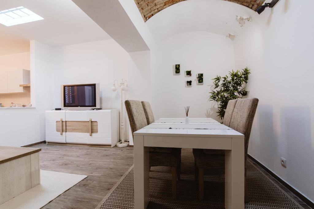 a dining room with a white table and chairs at Fernanda's House in Olhão