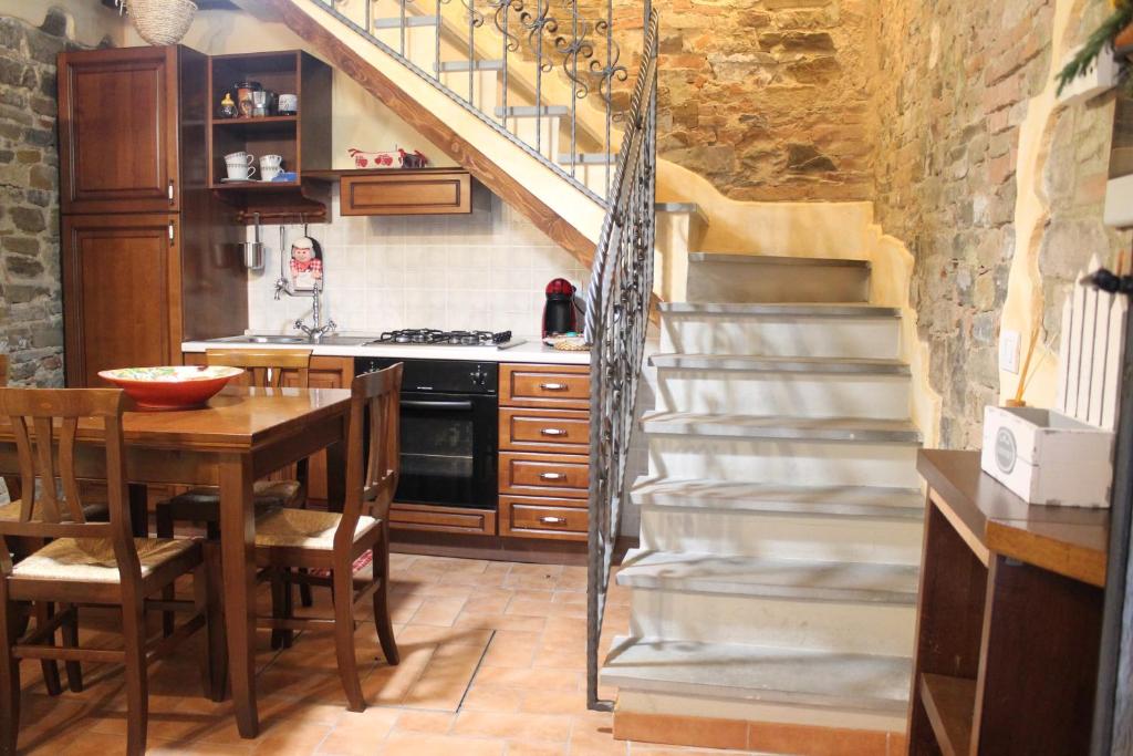 a kitchen with a staircase and a table in a kitchen at La Casina di Via Cresci, 14 in Montaione