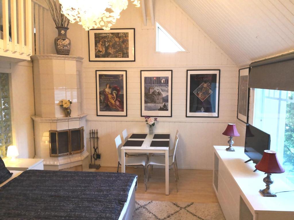 a living room with a dining room table and pictures on the wall at Lovely Mint Garden Studio in Vantaa