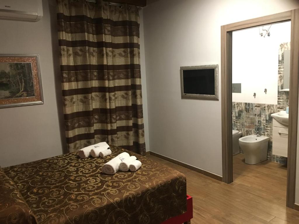 a hotel room with a bed and a bathroom at B&B Magada in Messina