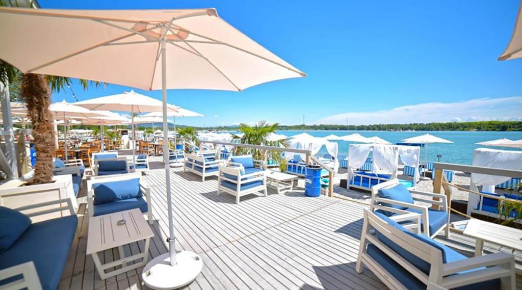 a deck with chairs and an umbrella and the water at LupaGlamping in Budakalász