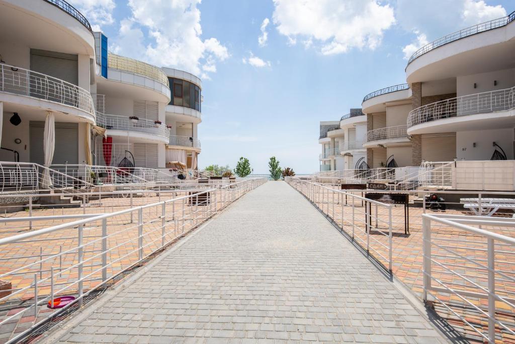 a long walkway between buildings with cows on it at Apartament First Line in Karolino-Buhaz