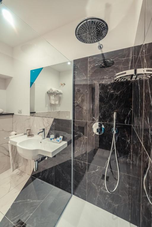 a bathroom with a sink and a shower at Nautilus Hotel in Giardini Naxos