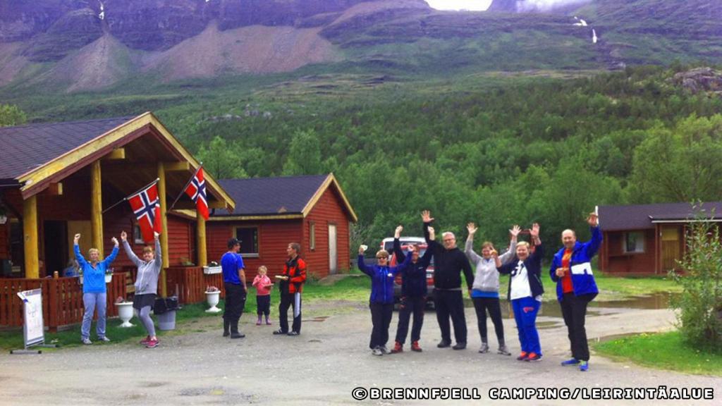 a group of people standing in front of a cabin at Brennfjell Camping in Skibotn
