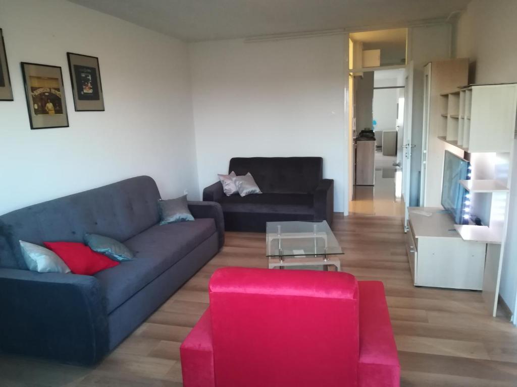 a living room with a blue couch and a pink stool at Apartman Tonika in Pula