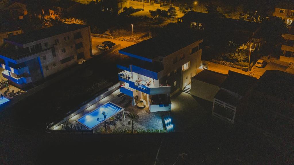 eine Aussicht über ein Gebäude mit einem Pool in der Nacht in der Unterkunft Apartments Pool Villa Aldura in Novalja