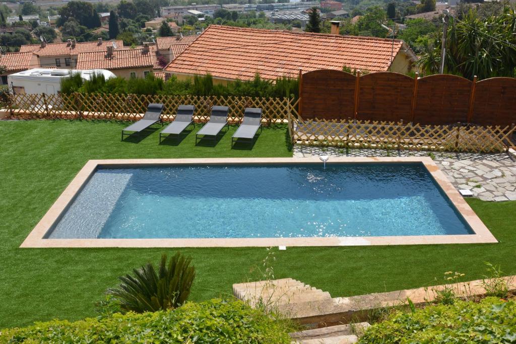 une piscine avec des chaises longues et une clôture dans l'établissement Villa ZEN, à Saint-Laurent-du-Var