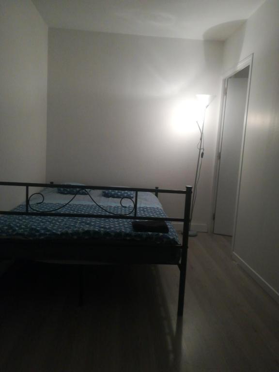 a bed in a room with a light next to a door at A 20 minutes de Paris in Sarcelles