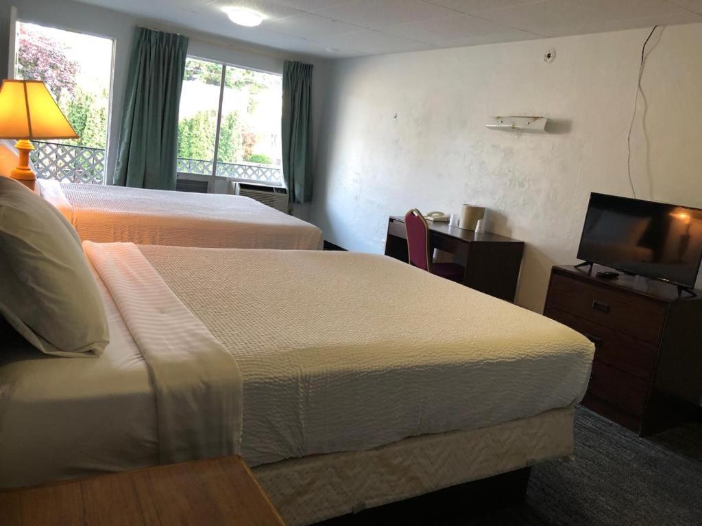 a hotel room with two beds and a flat screen tv at Portland Super Value Inn in Portland