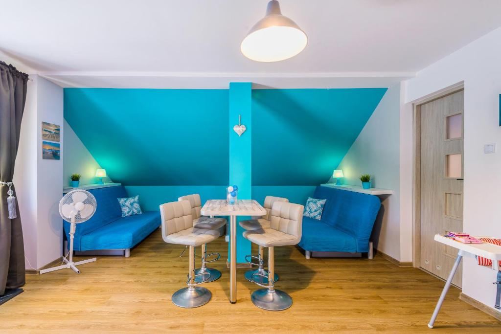 a blue room with a table and chairs at Verona in Kąty Rybackie