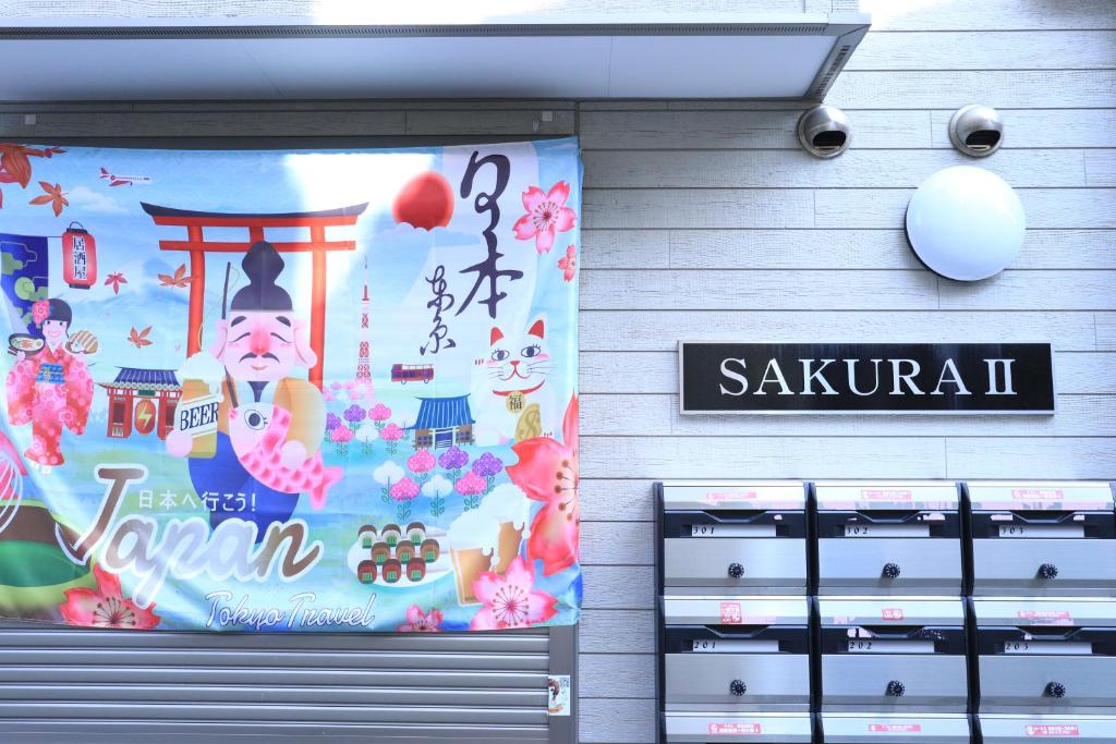 a sign on the side of a building with a sign for a sushi shop at Tokyo Sakura hotel in Tokyo