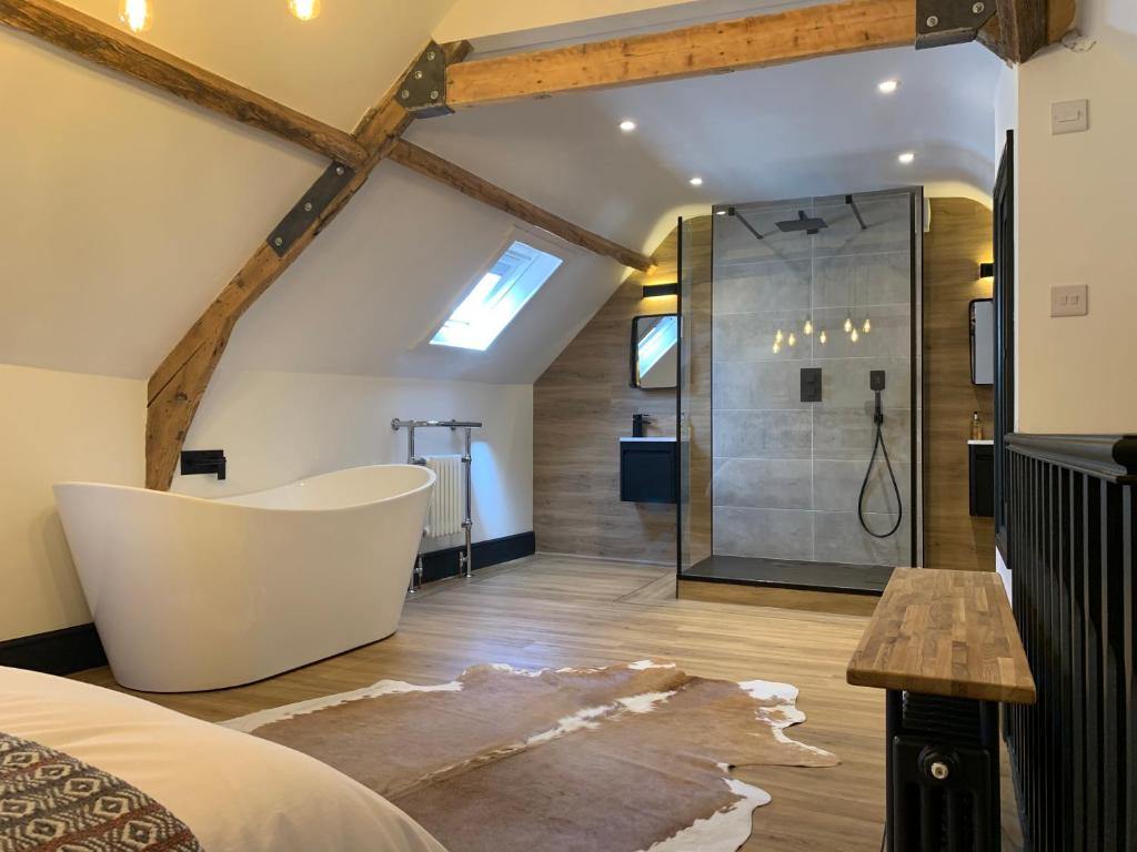 a bedroom with a large bathroom with a tub and a shower at The Old Post Office in Whitby