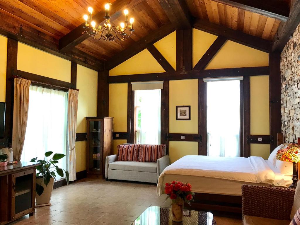 a bedroom with a bed and a couch and windows at Rothenburg Lodge in Wujie