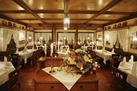 Hotel-Restaurant Esbach Hof في كيتسينغن: غرفة طعام بها طاولات بيضاء وورود