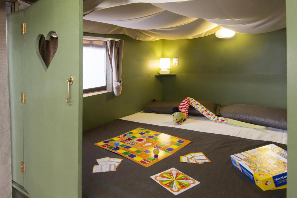 a room with a bed with a child laying on it at Camping Mare Monti in Sestri Levante