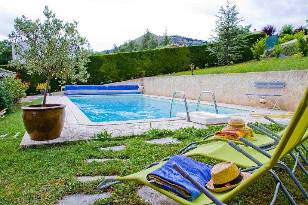 un patio con piscina y una silla con sombrero en Suite familiale de charme en Provence en Mirabeau