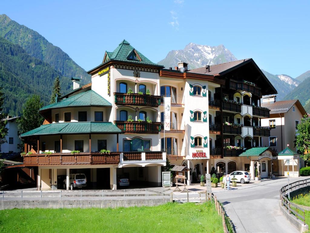 un gran edificio con una montaña en el fondo en Hotel Pramstraller en Mayrhofen