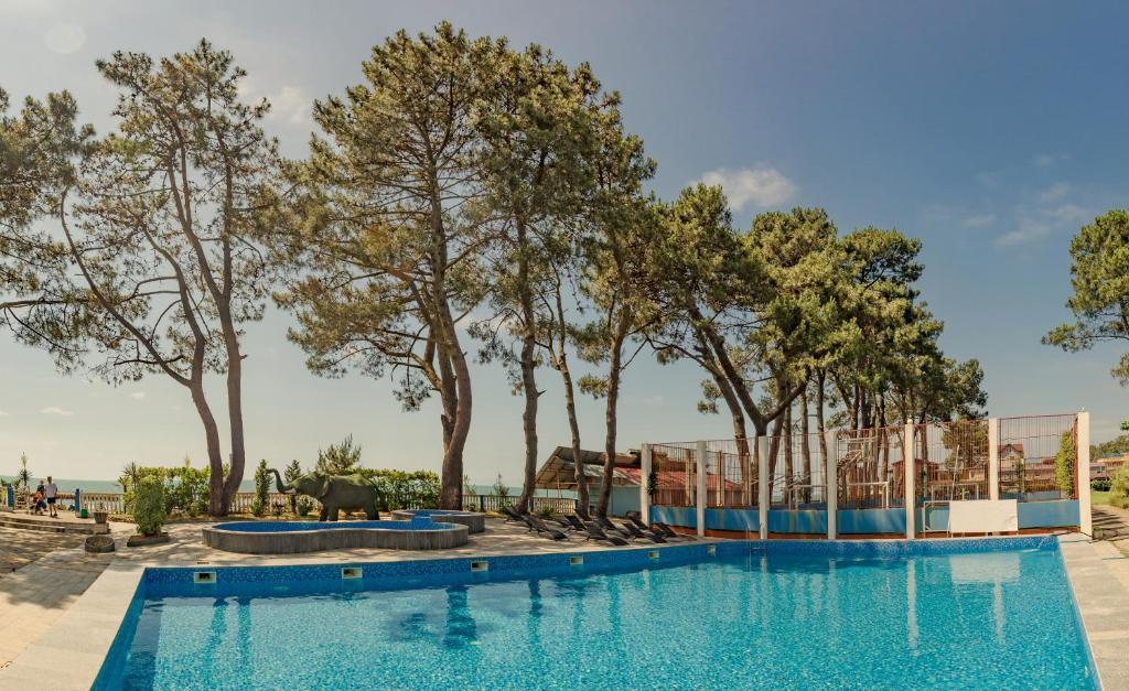 Kolkhida Resort & Spa في يوريكي: مسبح يوجد اشجار في الخلف