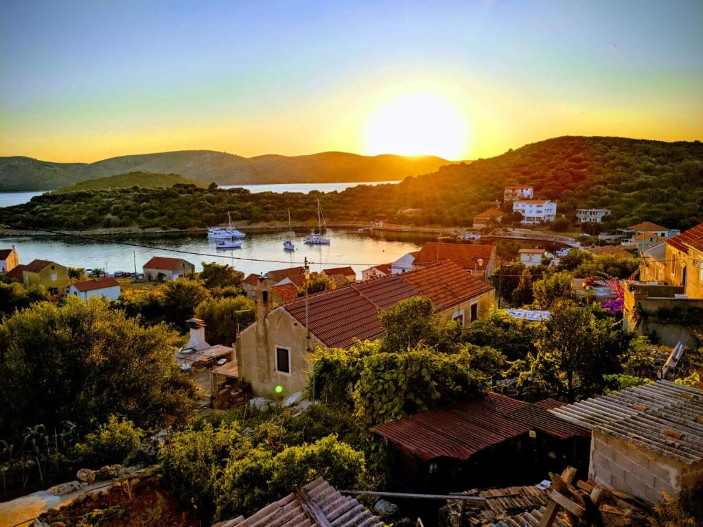 una puesta de sol sobre un pequeño pueblo con puerto en Apartments Marko Rava en Rava