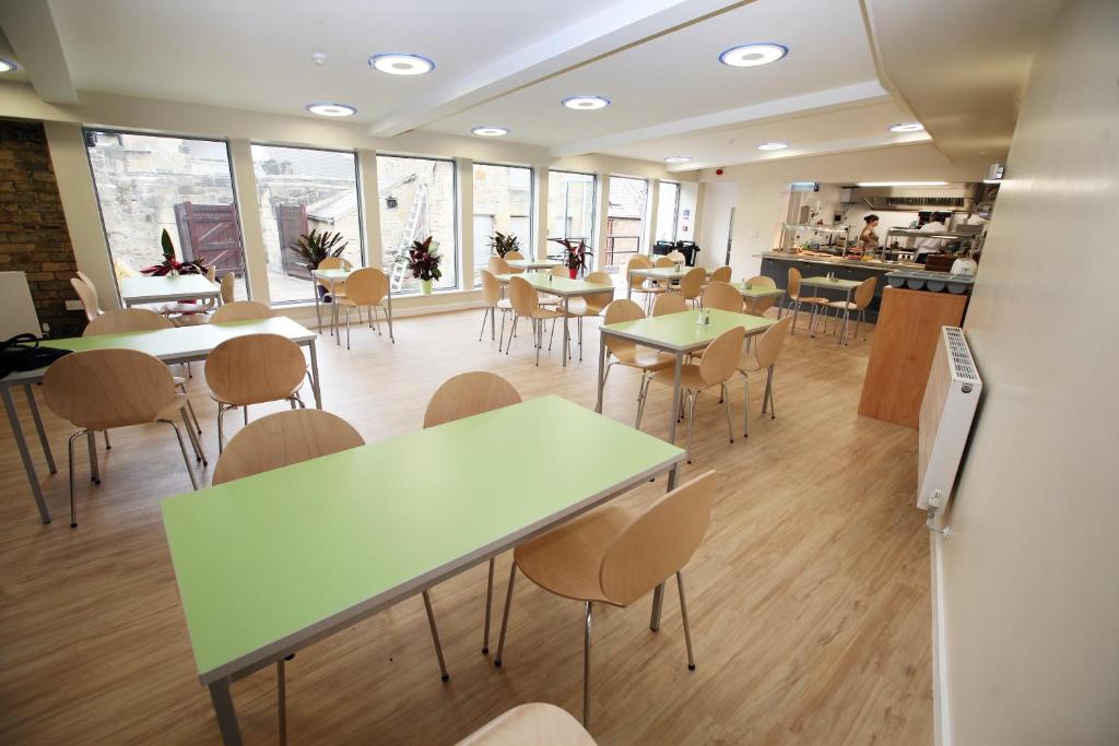een eetkamer met tafels, stoelen en ramen bij Alnwick Youth Hostel in Alnwick