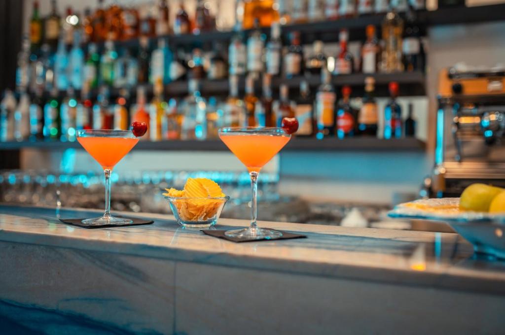 two glasses of orange cocktails sitting on a bar at Nautilus Hotel in Giardini Naxos