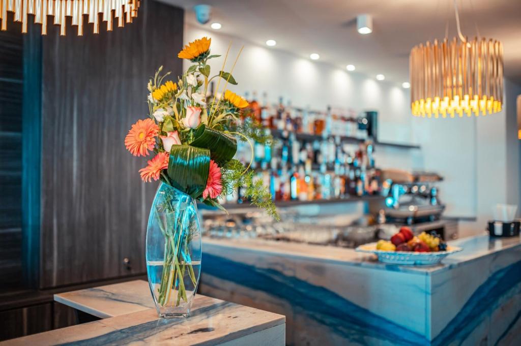 a vase filled with flowers sitting on a counter at Nautilus Hotel in Giardini Naxos