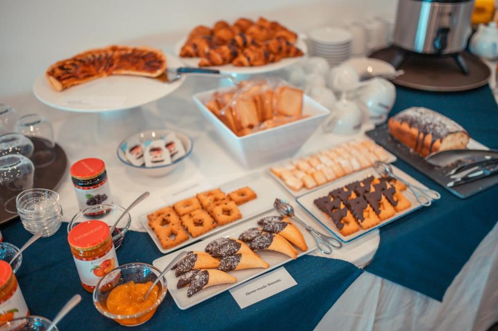 a table topped with different types of pastries and desserts at Nautilus Hotel in Giardini Naxos