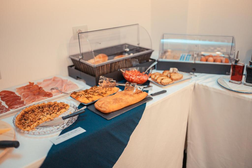 a table topped with different types of bread and pastries at Nautilus Hotel in Giardini Naxos