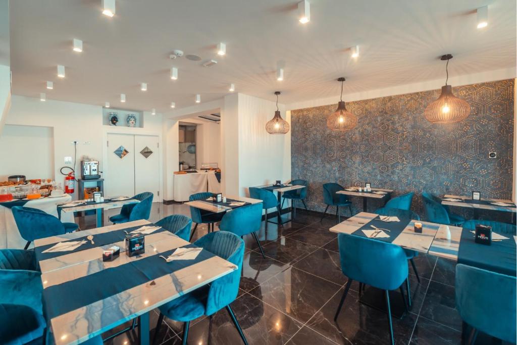 a restaurant with blue tables and blue chairs at Nautilus Hotel in Giardini Naxos