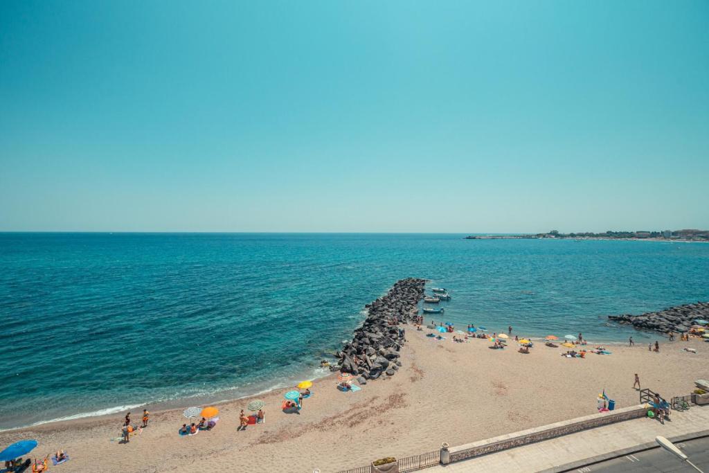 a group of people on a beach with umbrellas at Nautilus Hotel in Giardini Naxos