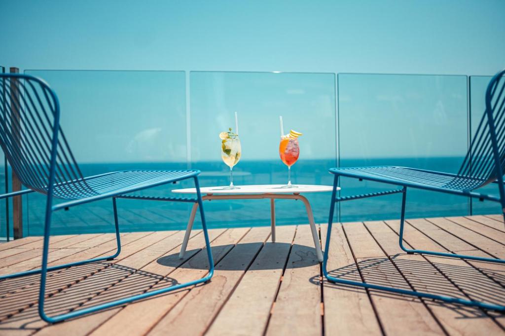 two chairs and a table with two vases on it at Nautilus Hotel in Giardini Naxos