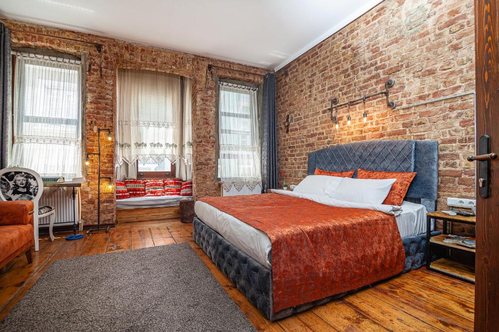 a bedroom with a bed and a brick wall at Historic Galata in Istanbul