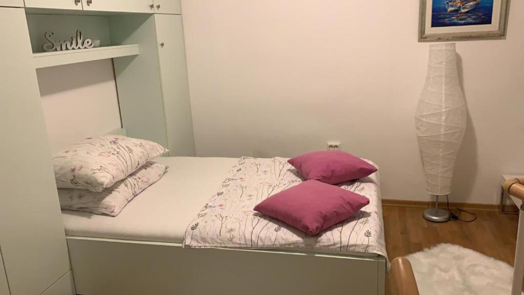 1 cama pequeña con 2 almohadas encima en Apartman Paula, en Biograd na Moru