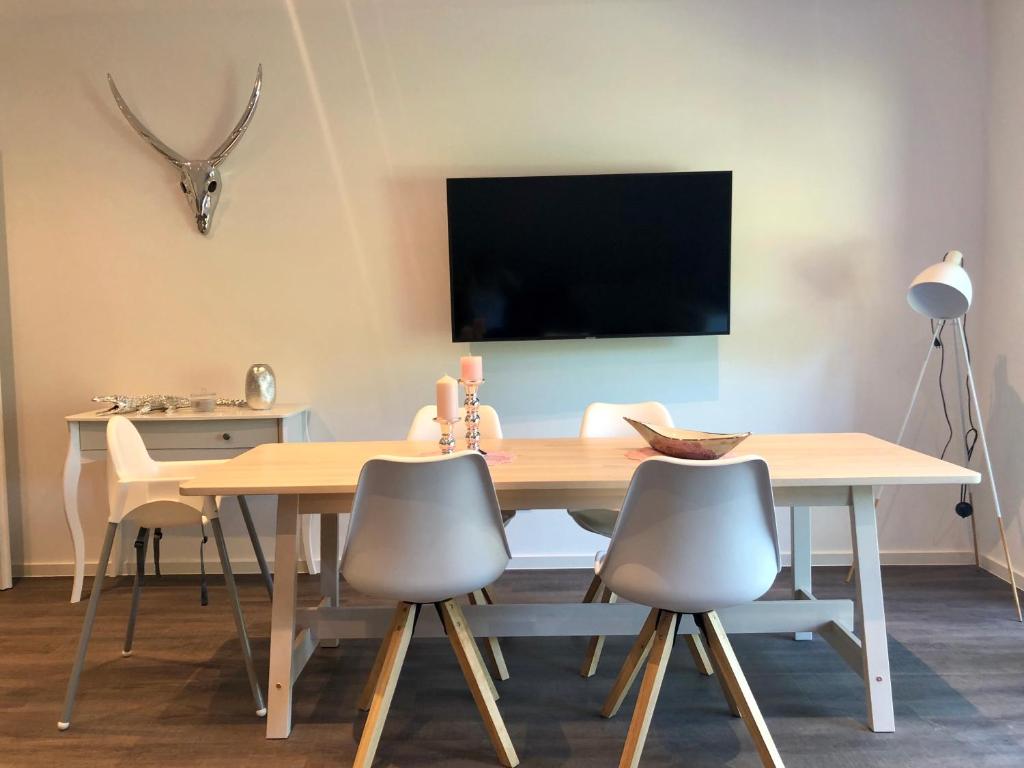 a dining room with a table and chairs and a television at Ferienwohnung Hünzingen in Walsrode