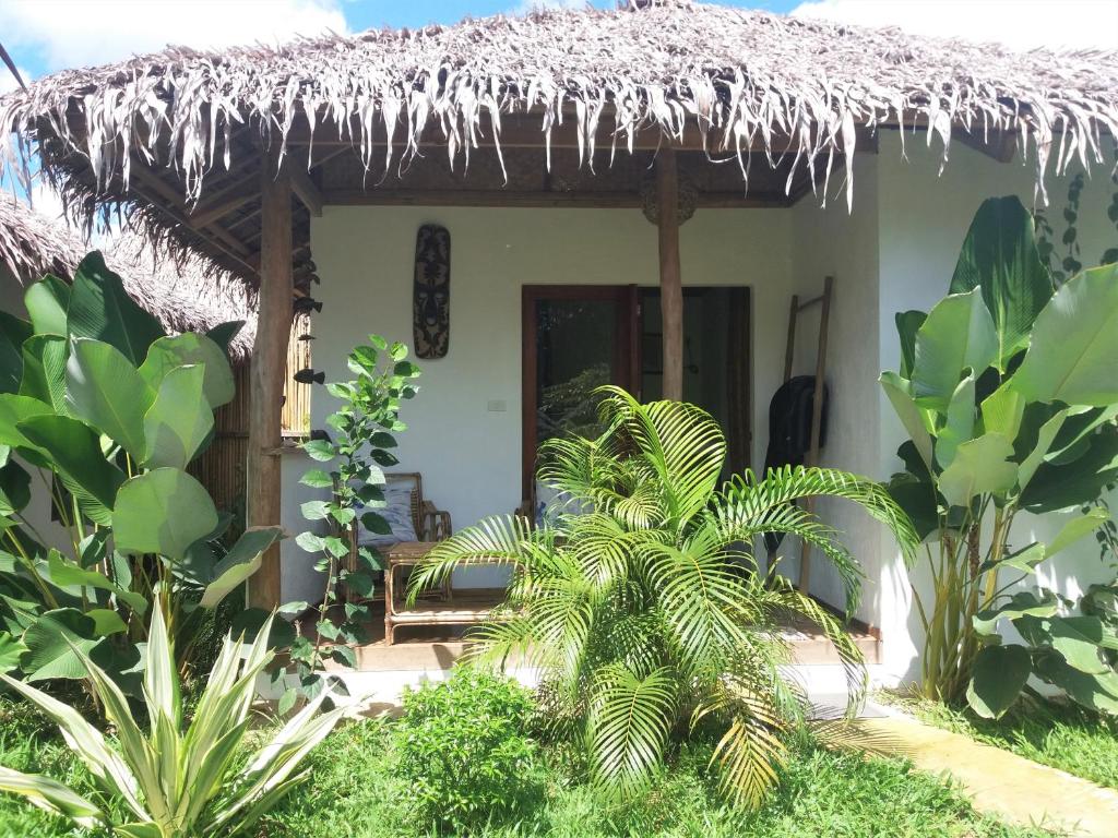 a small house with a thatched roof at Valerie Lodge in San Vicente