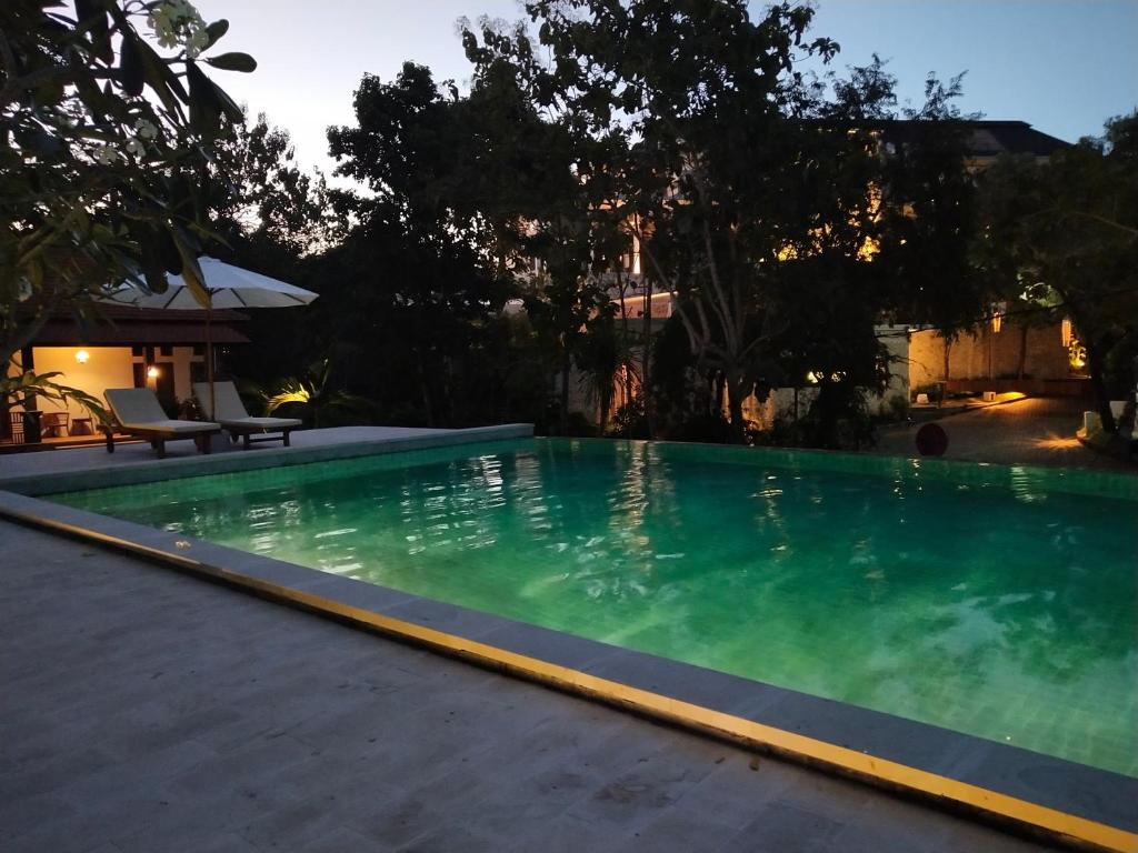 einen Pool mit grünem Wasser im Hinterhof in der Unterkunft villa pulu uluwatu bali in Uluwatu