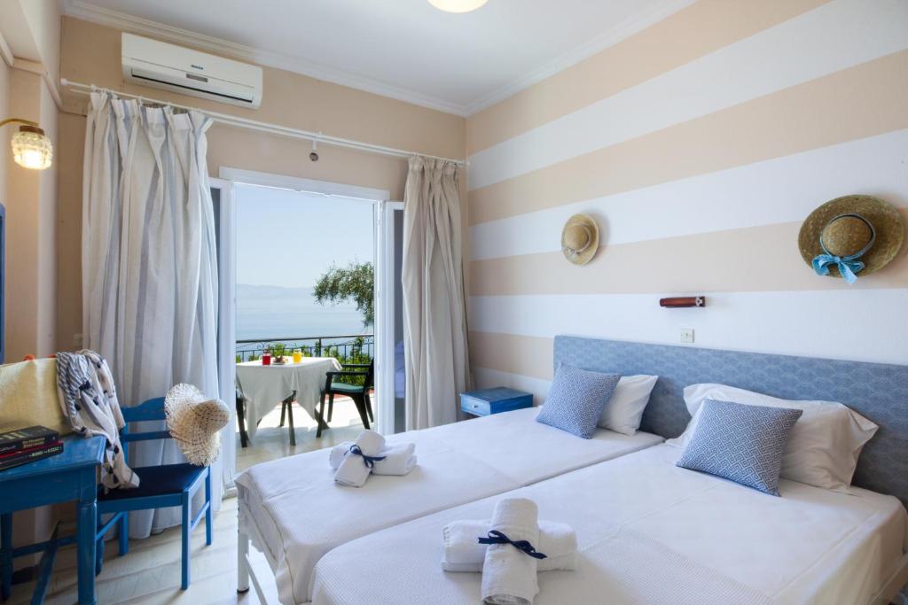 a hotel room with two beds and a view of the ocean at Casa dei Venti - Sea View Apartments - 100m from the beach in Benitses