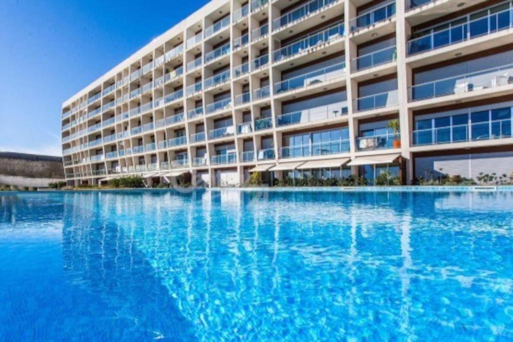 un gran edificio con una gran piscina de agua en Lisbon Metro & Pool Apartment, en Lisboa