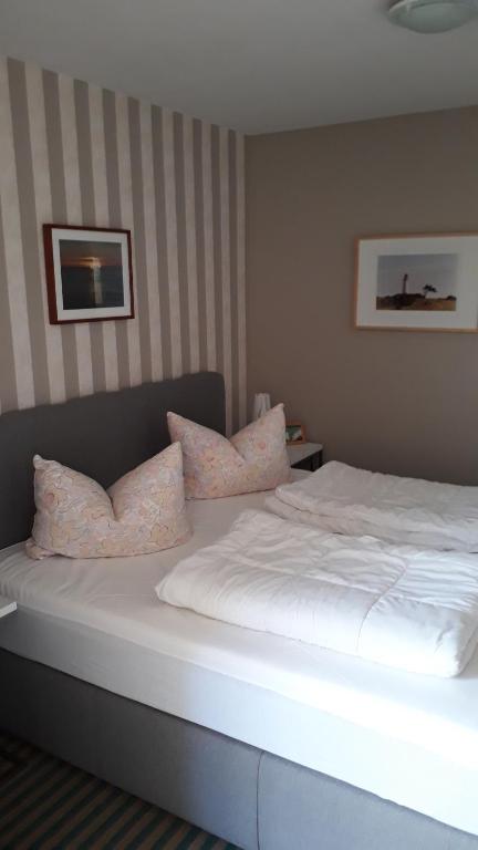 1 dormitorio con 1 cama con sábanas y almohadas blancas en Fewo Kasch, en Binz