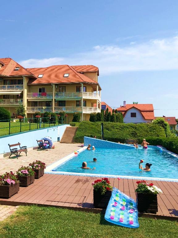 a large swimming pool with people in a resort at Furedi Apartman in Balatonfüred