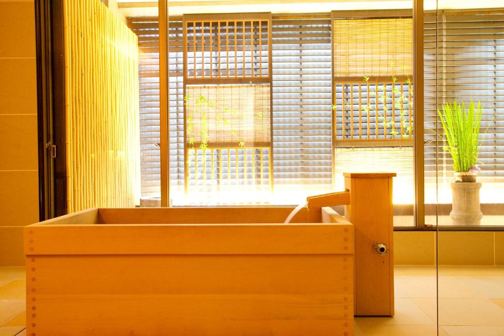 a wooden bath tub in a room with a window at Kizashi The Suite 京都祇園 in Kyoto