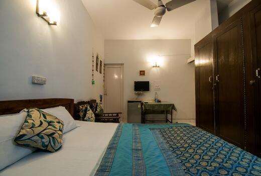 a bedroom with a bed and a desk in it at Comfort Point Bed & Breakfast in New Delhi