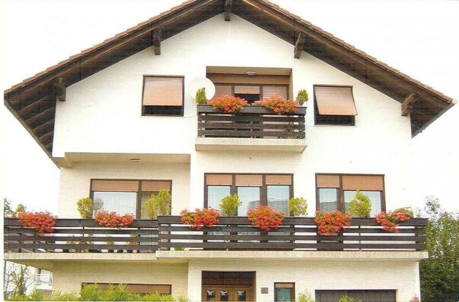 uma casa branca com vasos de plantas na varanda em Apartman Jadranka em Zaprešić